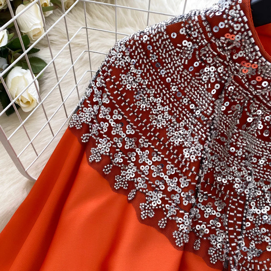 Loose satin blouse with long sleeves and batwing neck, with embroidered beads and high-quality sequins