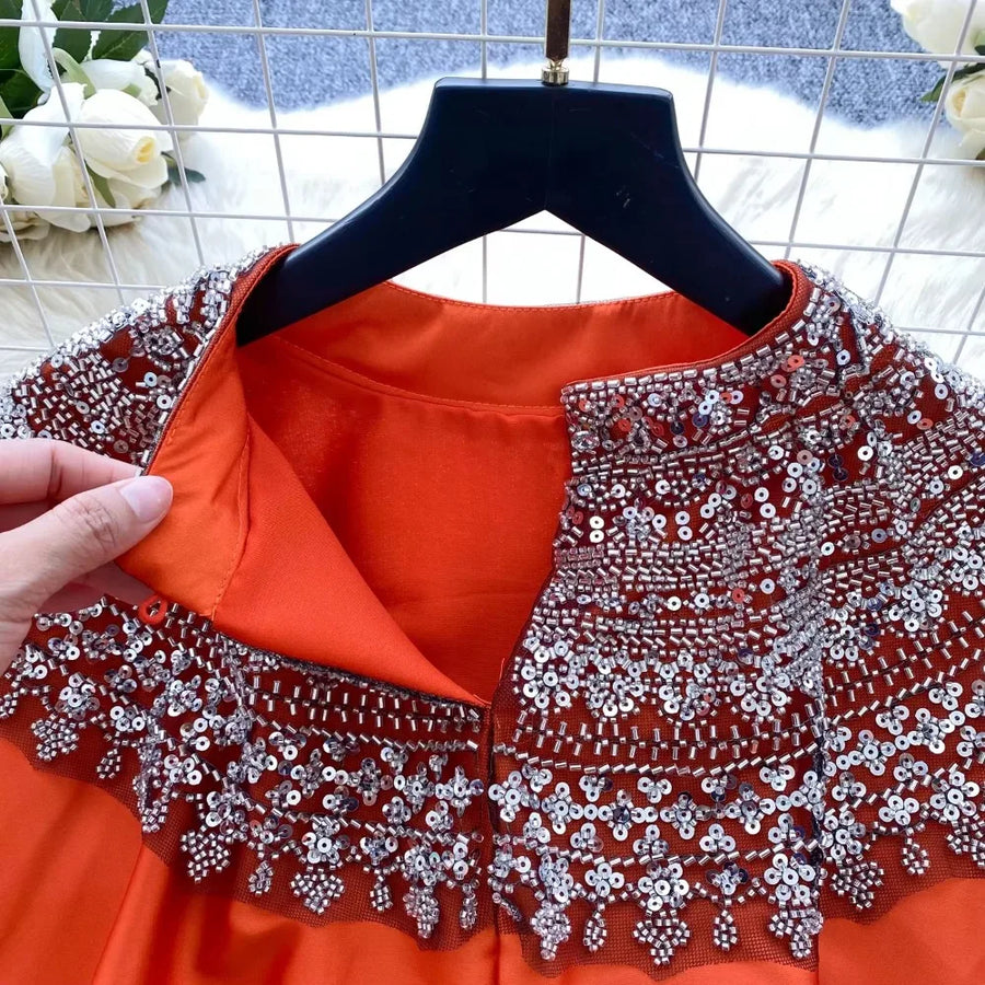 Loose satin blouse with long sleeves and batwing neck, with embroidered beads and high-quality sequins