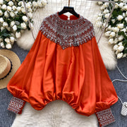 Loose satin blouse with long sleeves and batwing neck, with embroidered beads and high-quality sequins